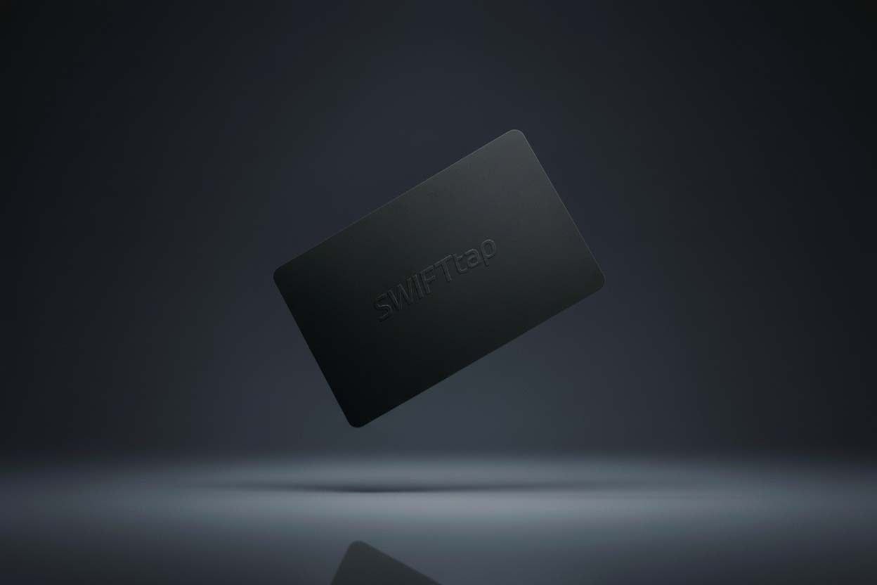 A matte black SWIFTtap NFC card floating against a dark ground