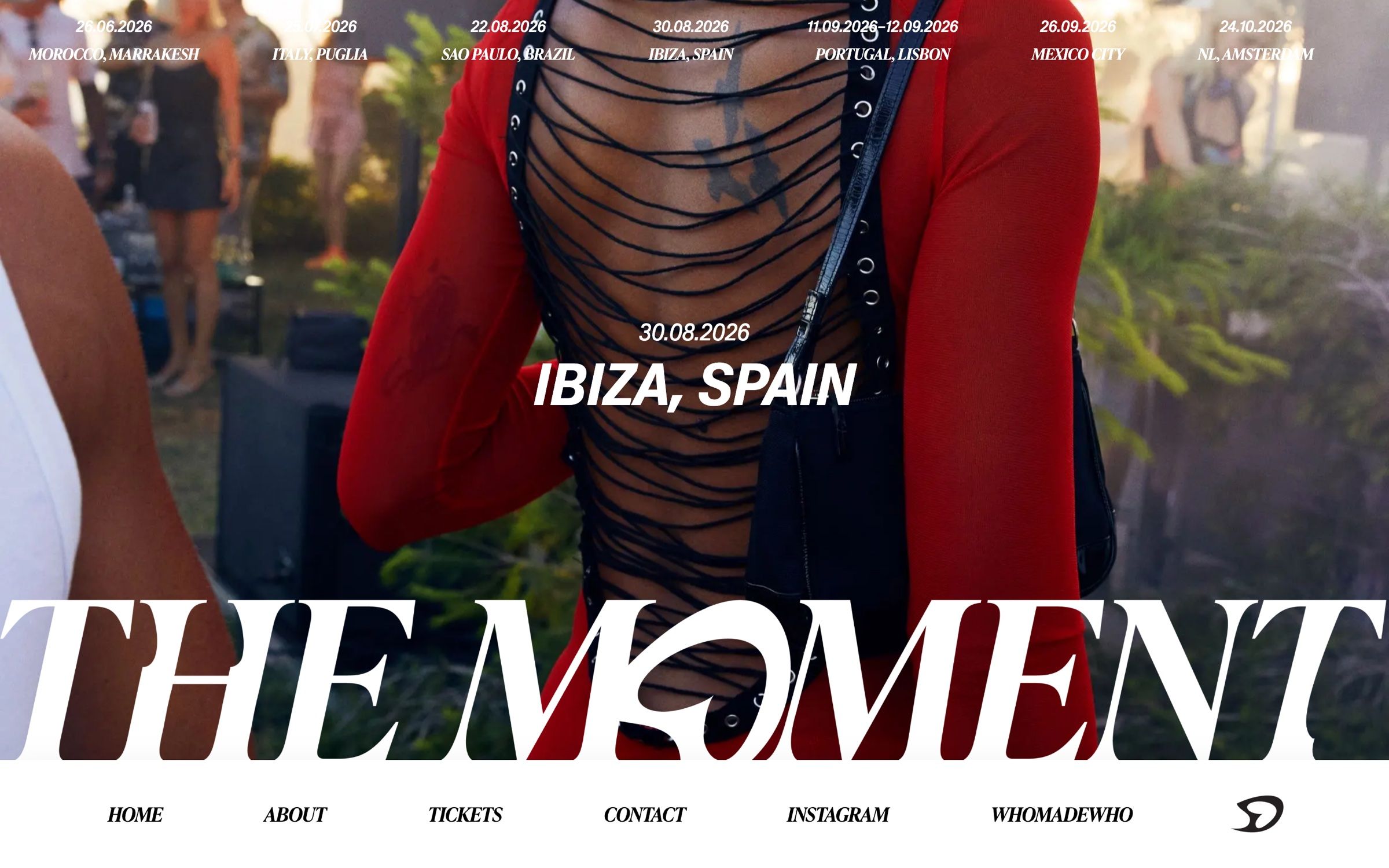 The Ibiza event page on desktop, a full-screen photo of a red open-back dress under the date, the city and a huge The Moment wordmark