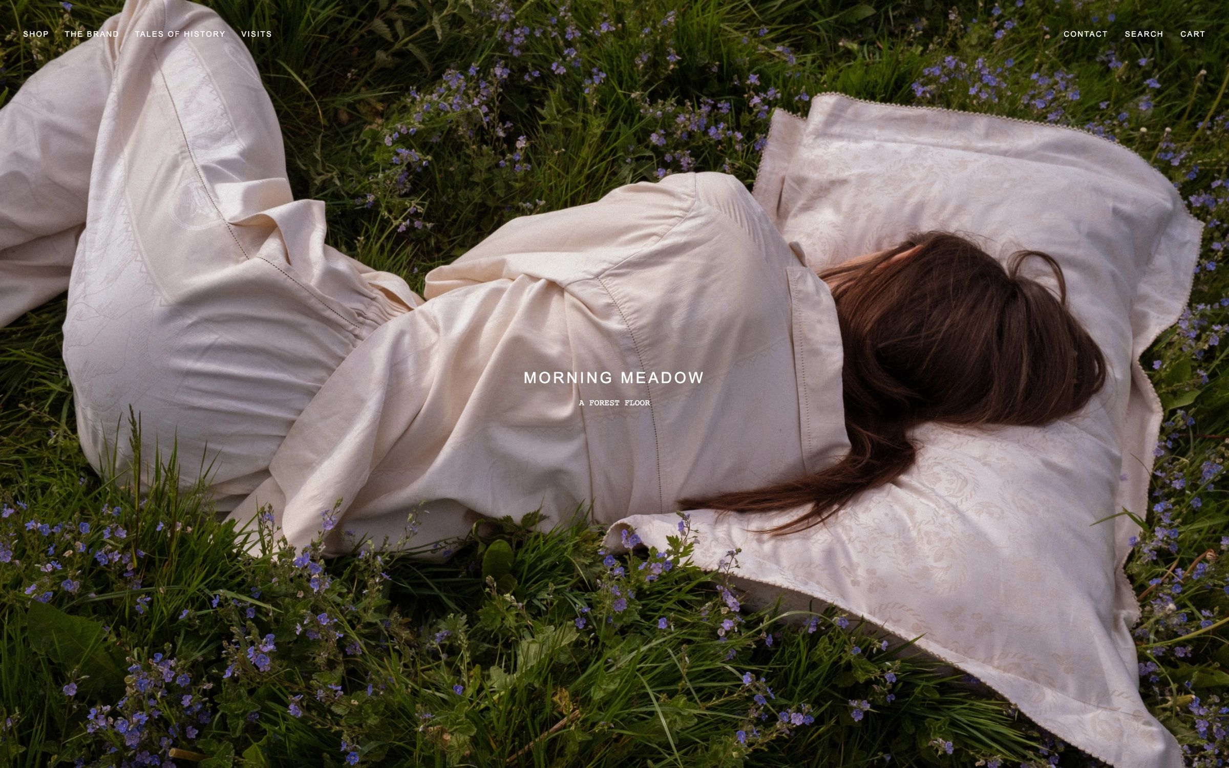 The Morning Meadow story page on desktop, a woman lying in a flowering meadow in Avillafranciska bedding