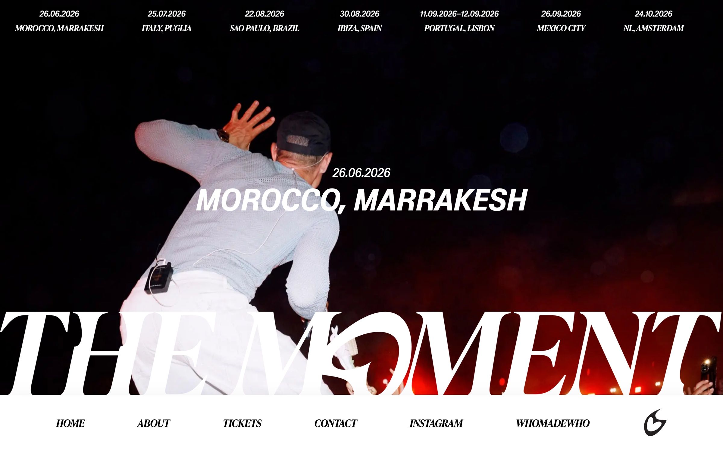 The Marrakesh event page on desktop, a performer seen from behind on stage above the giant The Moment wordmark